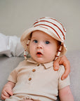baby wearing beige rib romper and matching hat