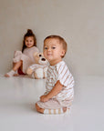 Child wearing beige cotton muslin shorts while sitting
