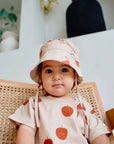 Child wearing beige slub short sleeve t-shirt with fruit print and front pocket front view