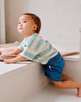 Child wearing blue cotton denim shorts side view