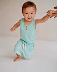 Child wearing light blue cotton slub tank top with wooden buttons front view