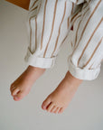 Child wearing white cotton terry pants with beige stripes closeup