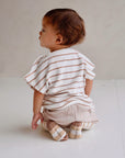 Toddler wearing beige striped cotton terry shirt with wooden buttons back view