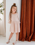 girl wearing cream pink organic cotton muslin dress