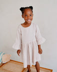 girl wearing cream pink organic cotton muslin dress