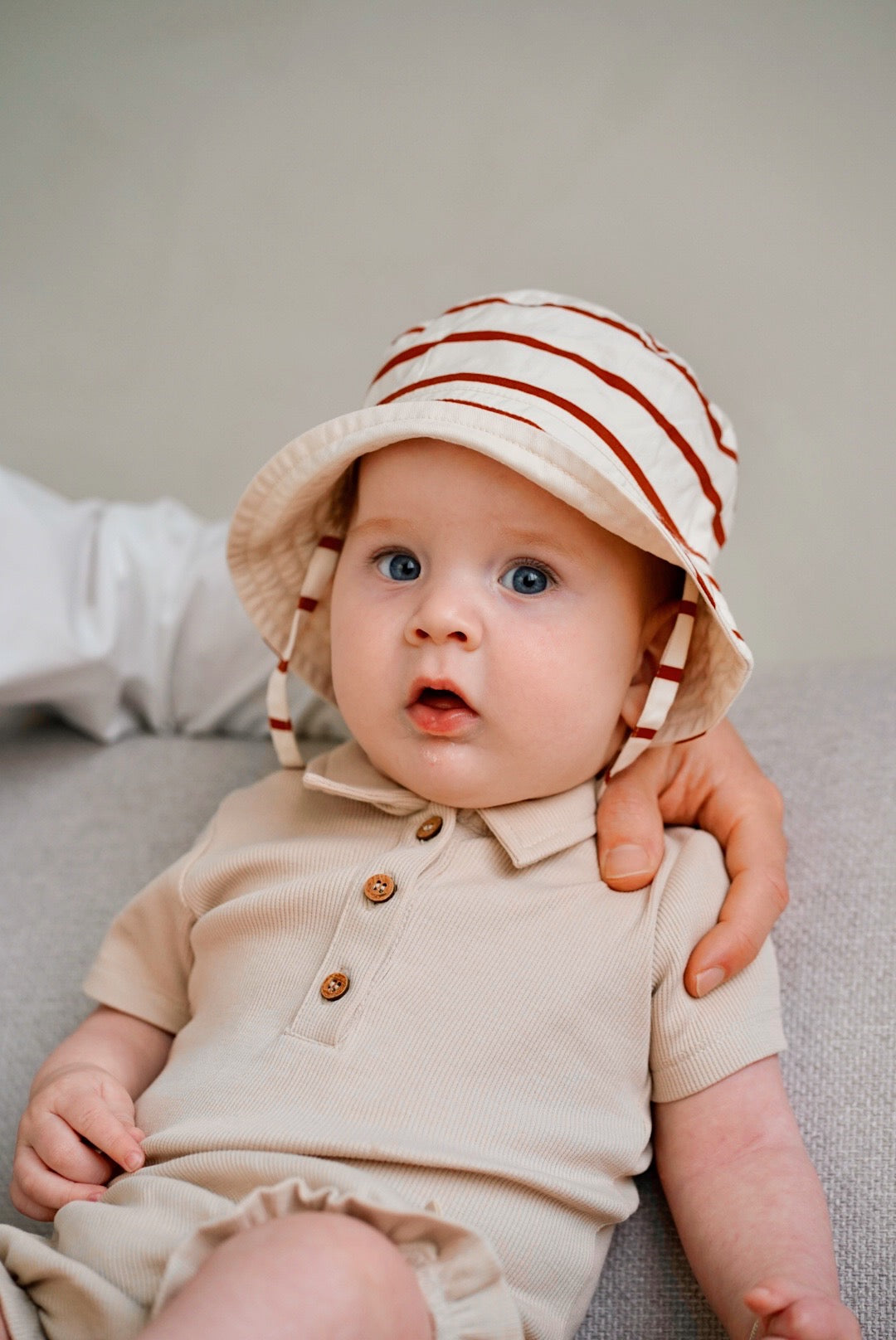 baby wearing beige rib romper and matching hat