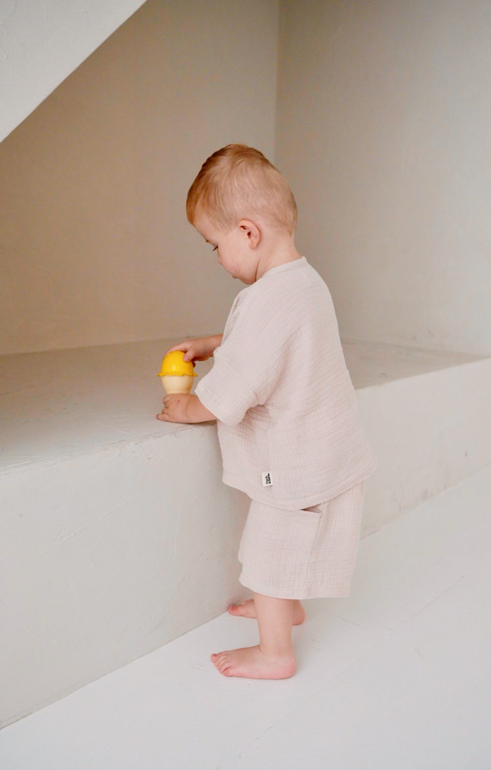 toddler wearing beige cotton slub long sleeve t-shirt side view