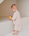 toddler wearing beige cotton slub long sleeve t-shirt side view