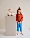 Child wearing blue cotton denim pants with drawstring waist and cargo pockets