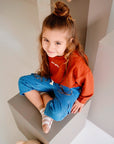 Child wearing blue cotton denim pants while sitting
