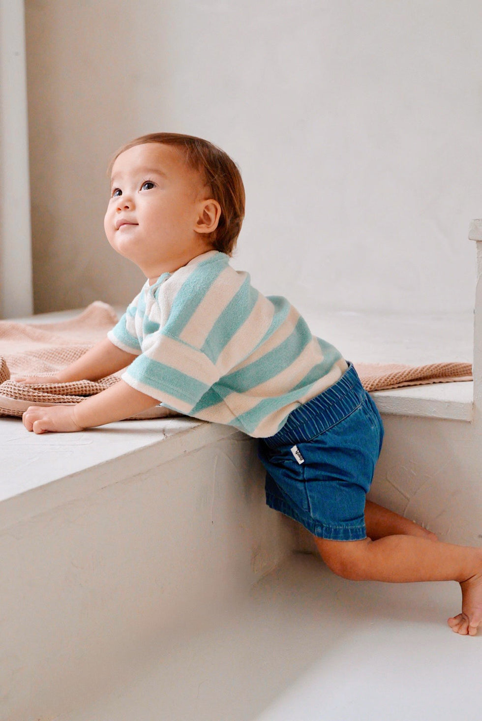 Child wearing blue cotton denim shorts side view