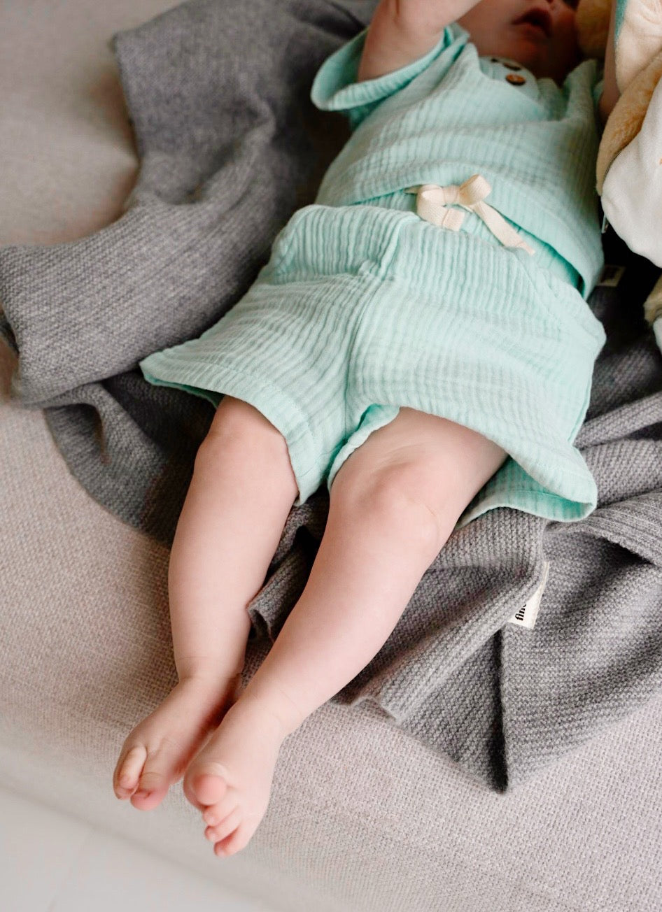 Child wearing light blue cotton muslin shorts with light blue t-shirt