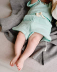 Child wearing light blue cotton muslin shorts with light blue t-shirt