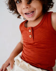 Child wearing red cotton slub tank top with wooden buttons front view