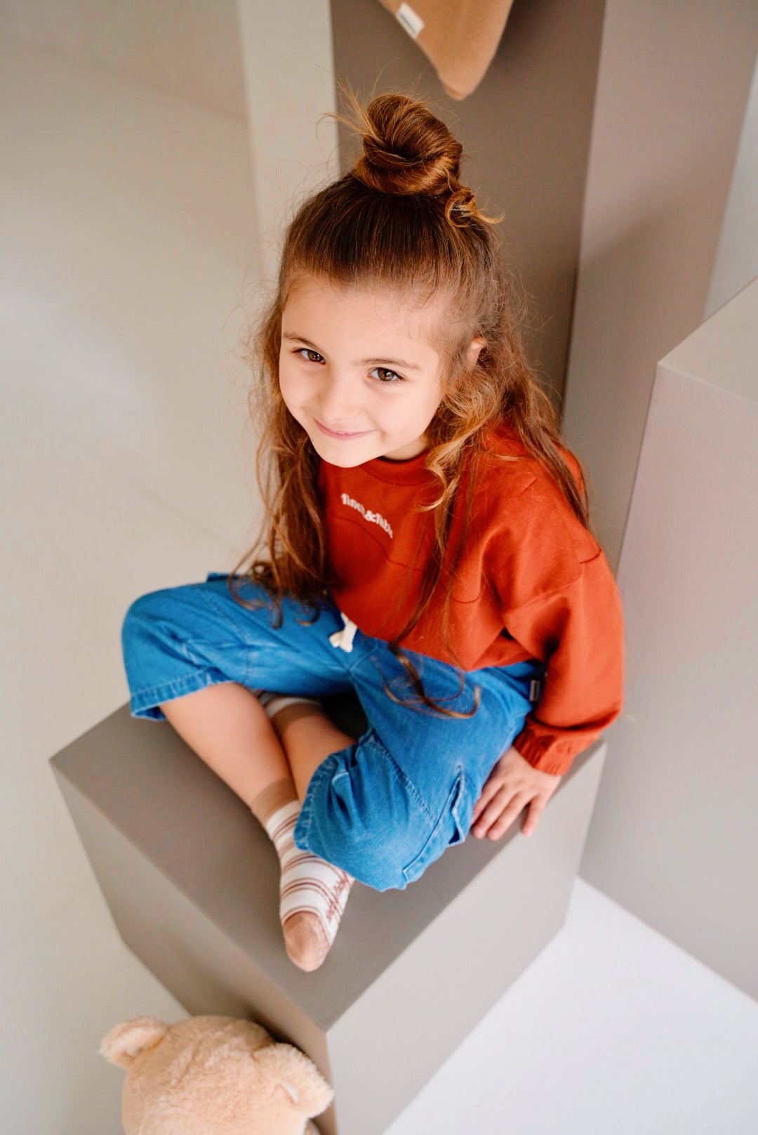 child wearing red fleece sweatshirt with denim pants close up