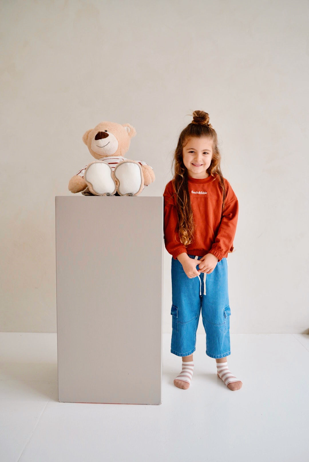 child wearing red fleece sweatshirt with denim pants front view