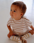 Toddler wearing beige striped cotton terry shirt with wooden buttons front view